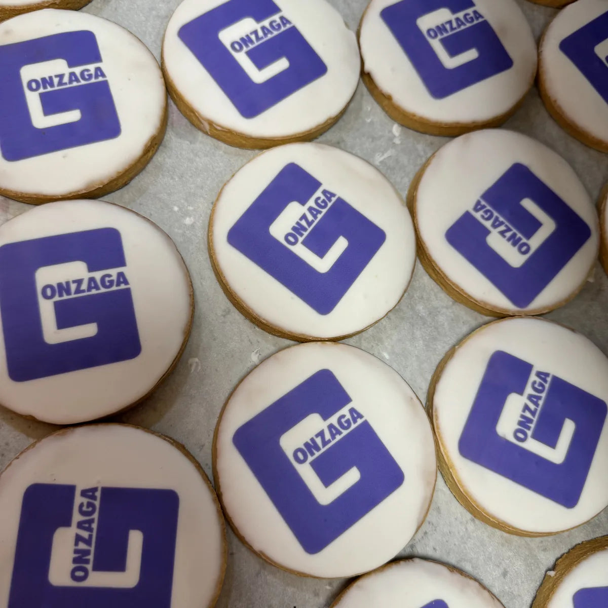 An institution logo printed across a batch of custom cookies