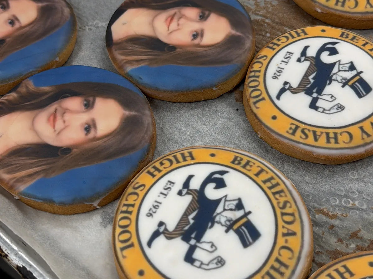 An assortment of finished portrait and school-emblem cookies